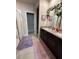Bathroom featuring a double sink vanity with granite counters, decorative mirror, and a glass-enclosed shower at 3072 Cassidy Ln, Haines City, FL 33844
