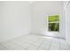 A clean bedroom boasts bright white walls, white tile floors, and a window providing ample natural light at 441 Tree Shore Dr, Orlando, FL 32825