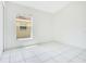 Bright bedroom with white tile flooring, a window providing natural light, and fresh white walls at 441 Tree Shore Dr, Orlando, FL 32825