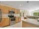 Well-equipped kitchen with stainless steel appliances, light wood cabinets, and a view of the eat-in kitchen area at 441 Tree Shore Dr, Orlando, FL 32825