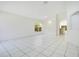 Bright living room with white tile flooring, neutral walls, and an arched doorway leading to the kitchen at 441 Tree Shore Dr, Orlando, FL 32825