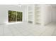 Bright living room featuring tile floors, ceiling fan, built-in shelving and sliding glass doors to the backyard at 441 Tree Shore Dr, Orlando, FL 32825