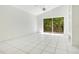 Sunny living room features tile flooring, ceiling fan, and sliding glass doors to the backyard with peaceful view at 441 Tree Shore Dr, Orlando, FL 32825