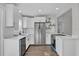 Modern kitchen featuring white cabinets, stainless steel appliances, and quartz countertops at 4722 Halliday Ln, Orlando, FL 32810
