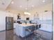 Modern kitchen with stainless steel appliances, a center island, and sleek white cabinets at 4731 Clock Tower Dr # 401, Kissimmee, FL 34746