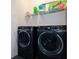 Laundry room with new, front-loading washer and dryer and built-in shelves at 4731 Clock Tower Dr # 401, Kissimmee, FL 34746