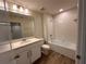 Bright bathroom featuring a bathtub with shower, vanity with modern fixtures, and wood-look tile floors at 5108 Rain Shadow Dr, St Cloud, FL 34772
