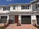 Charming townhome featuring a brick driveway, a one car garage, and an inviting rust colored front door at 5108 Rain Shadow Dr, St Cloud, FL 34772
