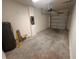 View of the empty garage with a concrete floor, white walls, water heater, and electrical panel at 5108 Rain Shadow Dr, St Cloud, FL 34772