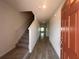 Inviting hallway featuring wood-look tile flooring, a staircase, and a view of the living space through glass doors at 5108 Rain Shadow Dr, St Cloud, FL 34772