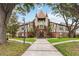 Unique condo building featuring brick and Tudor-style architecture with turrets and lush landscaping at 5413 Hansel Ave # K10, Orlando, FL 32809