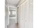 Hallway with closet doors leading to a bedroom that has a window, offering storage and access to living spaces at 5413 Hansel Ave # K10, Orlando, FL 32809