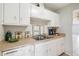 Efficient kitchen featuring clean countertops, white cabinetry, and a double stainless steel sink and faucet at 5413 Hansel Ave # K10, Orlando, FL 32809