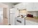 Compact kitchen with white cabinets, a refrigerator, and a stove, providing a simple cooking space at 5413 Hansel Ave # K10, Orlando, FL 32809