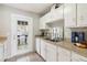 Well-lit kitchen featuring ample counter space, white cabinetry, and a garden door leading to the outside at 5413 Hansel Ave # K10, Orlando, FL 32809