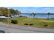 Scenic lake view with lush green grass, palm trees, benches, and boat parking at 5413 Hansel Ave # K10, Orlando, FL 32809