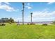Lakeside view of lawn area with picnic tables and palm trees on a sunny day at 5413 Hansel Ave # K10, Orlando, FL 32809