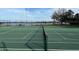 Two tennis courts with net and lake view at 5413 Hansel Ave # K10, Orlando, FL 32809