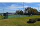 Community tennis court overlooking the water, surrounded by lush grass and greenery at 5413 Hansel Ave # K10, Orlando, FL 32809