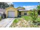Cute yellow house with a one-car garage and small front yard at 5633 Piney Ridge Dr, Orlando, FL 32808