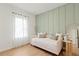 Inviting bedroom showcasing an accent wall, neutral tones, and soft natural light through sheer curtains at 6618 Sw 128Th Pl, Ocala, FL 34473