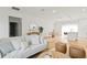 Bright living room features light hardwood floors, a modern sofa, and an open layout to kitchen and dining area at 6618 Sw 128Th Pl, Ocala, FL 34473