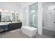 Bright bathroom featuring a soaking tub, glass shower and a modern vanity with double sinks at 7017 Via Carmel Way, Orlando, FL 32819