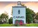 Carmel community entrance sign surrounded by lush greenery and flowers at 7017 Via Carmel Way, Orlando, FL 32819