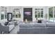 Bright living room featuring large windows, gray sofas, and a modern entertainment center at 7017 Via Carmel Way, Orlando, FL 32819