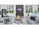 Bright living room featuring large windows, gray sofas, and a modern entertainment center at 7017 Via Carmel Way, Orlando, FL 32819