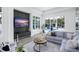 Bright living room with pool access, gray sofas, and a sleek entertainment setup at 7017 Via Carmel Way, Orlando, FL 32819