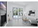 Bright living room with fireplace, modern decor and sliding glass doors to outside lounge and pool at 7017 Via Carmel Way, Orlando, FL 32819