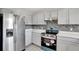 Modern kitchen with gray cabinets, new appliances, and tile backsplash at 1135 Madeira Key Way Way, Orlando, FL 32824