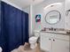 Cozy bathroom featuring a vanity, toilet, and shower with a blue curtain at 136 Pompano Beach Dr, Kissimmee, FL 34746
