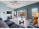 Comfortable living area with a sectional sofa, ceiling fan, and sliding glass doors to the patio at 136 Pompano Beach Dr, Kissimmee, FL 34746