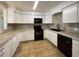 Modern kitchen with white cabinets and black appliances at 1361 Peters Dr, Leesburg, FL 34748