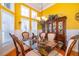 Elegant dining room bathed in sunlight, featuring a glass table and decorative china cabinet at 1485 Whitefriar Dr, Ocoee, FL 34761