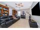 Cozy living room with ceiling fan, large windows, bookshelves, and a comfortable, oversized leather couch at 1485 Whitefriar Dr, Ocoee, FL 34761