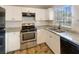 Modern kitchen with white cabinets, granite counters and stainless steel appliances at 1490 Lake Opal Dr, Apopka, FL 32703