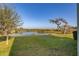 Serene backyard with lush grass and a peaceful lake view at 15107 Lake Claire Overlook Dr, Winter Garden, FL 34787