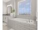 Bathroom features a large soaking tub and window at 15107 Lake Claire Overlook Dr, Winter Garden, FL 34787