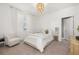 Bedroom with a queen bed, stylish chandelier, and comfortable armchair at 15107 Lake Claire Overlook Dr, Winter Garden, FL 34787