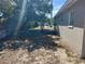 An open backyard with a shade tree and access to a metal fence on a sunny day at 1601 Pontiac Ct, Orlando, FL 32808