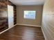 Charming bedroom featuring laminate flooring, a wood accent wall, and a neutral paint scheme at 1601 Pontiac Ct, Orlando, FL 32808