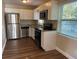 Modern kitchen featuring stainless steel appliances, granite countertops, and beautiful white cabinets and laminate flooring at 1601 Pontiac Ct, Orlando, FL 32808