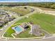 Aerial view of new residential development with central community pool, clubhouse, parking, and playground at 33425 Country House Dr, Sorrento, FL 32776