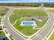 Aerial view of a new community with a playground, pool and clubhouse and parking surrounded by green space at 33425 Country House Dr, Sorrento, FL 32776