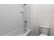 Bathroom featuring a white tiled shower-bathtub combination and toilet at 33425 Country House Dr, Sorrento, FL 32776