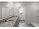 Bathroom featuring double granite countertop vanity, mirror, shower and tile floor at 33425 Country House Dr, Sorrento, FL 32776