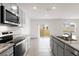Open kitchen design includes granite counters, stainless steel appliances and a view into the open living space at 33425 Country House Dr, Sorrento, FL 32776